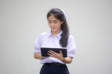 Portrait of thai high school student uniform beautiful girl using her tablet