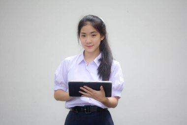 Portrait of thai high school student uniform beautiful girl using her tablet