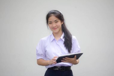 Portrait of thai high school student uniform beautiful girl using her tablet