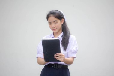 Portrait of thai high school student uniform beautiful girl using her tablet