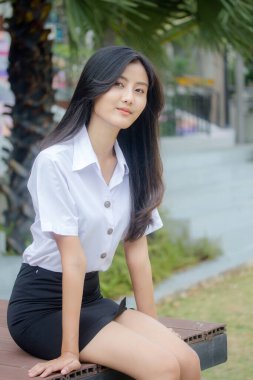 Taylandlı yetişkin öğrenci üniforması portresi. Güzel kız rahatla ve gülümse.