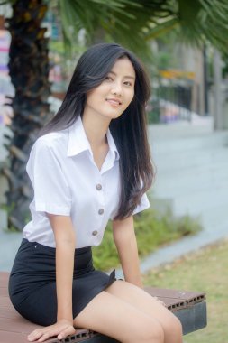 Taylandlı yetişkin öğrenci üniforması portresi. Güzel kız rahatla ve gülümse.