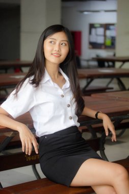 Taylandlı yetişkin öğrenci üniforması portresi. Güzel kız rahatla ve gülümse.