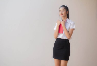 Taylandlı yetişkin öğrenci üniforması portresi. Güzel kız kırmızı kitabı okudu.