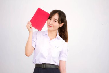 Asya Taylandlı lise öğrencisi üniforması. Güzel kız bir kitap okumuş.