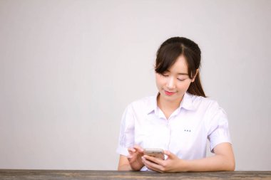 Taylandlı liseli üniformasının portresi. Genç güzel kız mutlu ve rahat.