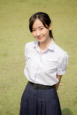 Taylandlı liseli üniformasının portresi. Genç güzel kız mutlu ve rahat.