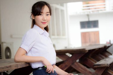 Taylandlı liseli üniformasının portresi. Genç güzel kız mutlu ve rahat.