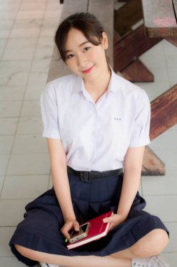 Taylandlı liseli üniformasının portresi. Genç güzel kız mutlu ve rahat.