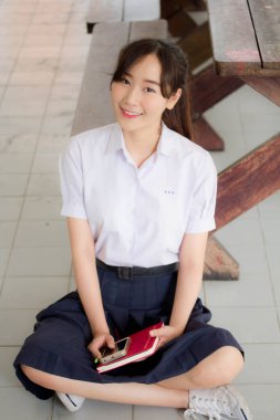 Taylandlı liseli üniformasının portresi. Genç güzel kız mutlu ve rahat.