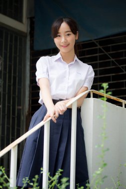 Taylandlı liseli üniformasının portresi. Genç güzel kız mutlu ve rahat.