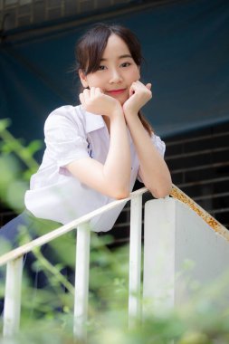 Taylandlı liseli üniformasının portresi. Genç güzel kız mutlu ve rahat.