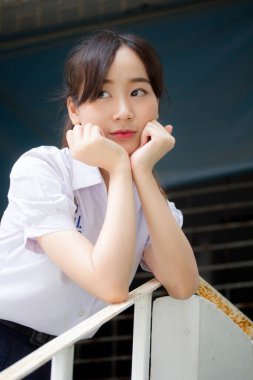 Taylandlı liseli üniformasının portresi. Genç güzel kız mutlu ve rahat.