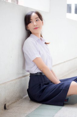 Taylandlı liseli üniformasının portresi. Genç güzel kız mutlu ve rahat.