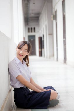 Taylandlı liseli üniformasının portresi. Genç güzel kız mutlu ve rahat.
