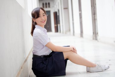 Taylandlı liseli üniformasının portresi. Genç güzel kız mutlu ve rahat.