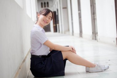 Taylandlı liseli üniformasının portresi. Genç güzel kız mutlu ve rahat.