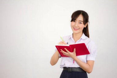 Asya Taylandlı lise öğrencisi üniforması. Güzel kız bir kitap okumuş.