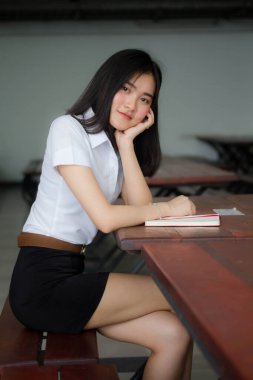 Taylandlı yetişkin öğrenci üniforması portresi. Güzel kız rahatla ve gülümse.