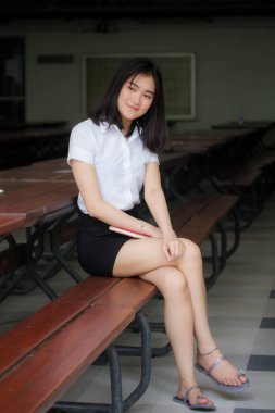 Taylandlı yetişkin öğrenci üniforması portresi. Güzel kız rahatla ve gülümse.