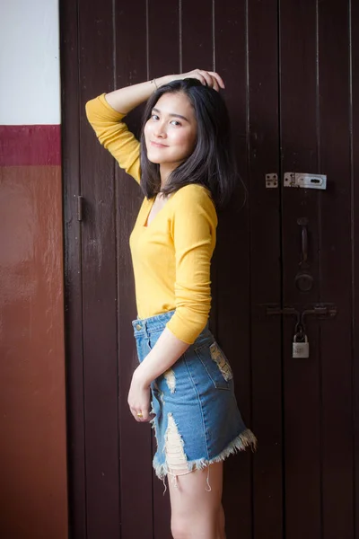 タイの肖像ジーンズスカート黄色のシャツ大人美しい女の子リラックスして笑顔 — ストック写真