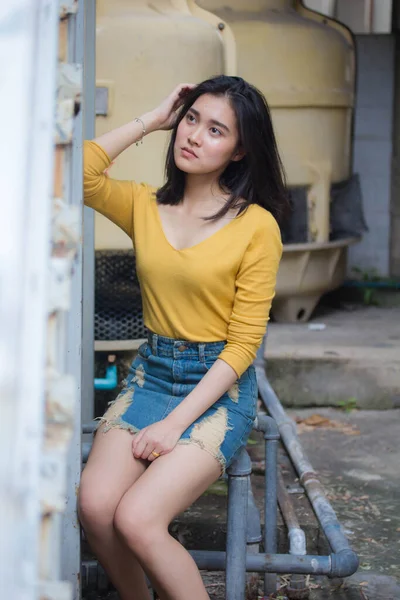 タイの肖像ジーンズスカート黄色のシャツ大人美しい女の子リラックスして笑顔 — ストック写真