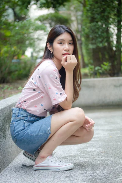 泰国人的画像漂亮的女孩粉红衬衫蓝牛仔裤放松微笑 — 图库照片
