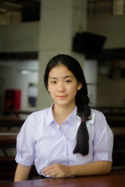 Taylandlı liseli üniformasının portresi. Genç güzel kız mutlu ve rahat.