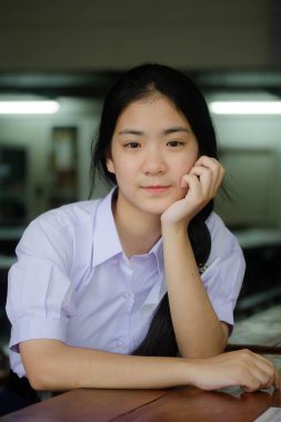 Taylandlı liseli üniformasının portresi. Genç güzel kız mutlu ve rahat.