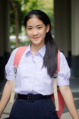 Taylandlı liseli üniformasının portresi. Genç güzel kız mutlu ve rahat.