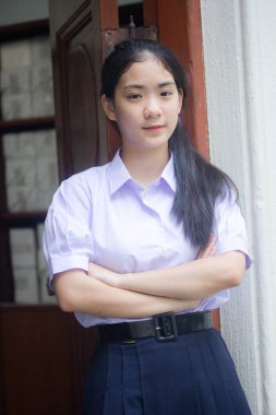 Taylandlı liseli üniformasının portresi. Genç güzel kız mutlu ve rahat.