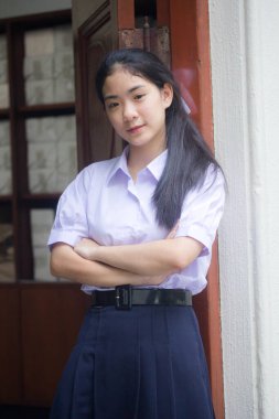 Taylandlı liseli üniformasının portresi. Genç güzel kız mutlu ve rahat.