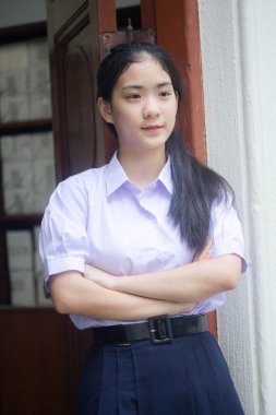 Taylandlı liseli üniformasının portresi. Genç güzel kız mutlu ve rahat.