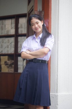 Taylandlı liseli üniformasının portresi. Genç güzel kız mutlu ve rahat.