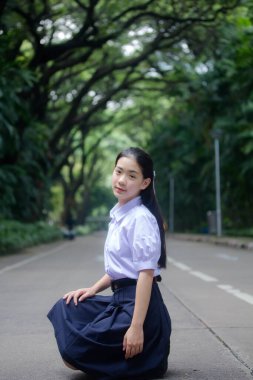 Taylandlı liseli üniformasının portresi. Genç güzel kız mutlu ve rahat.