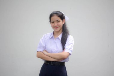 Taylandlı liseli üniformasının portresi. Genç güzel kız mutlu ve rahat.