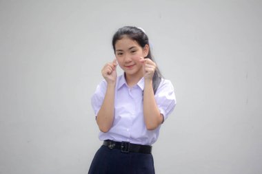 Taylandlı liseli üniformasının portresi. Güzel bir kız kalbini verir.