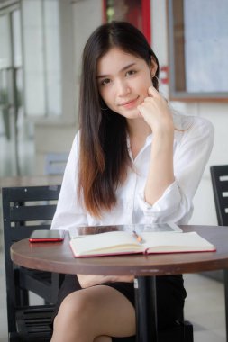 Tayland porseleni, yetişkin ofis kızı beyaz gömlek. Kitap yaz.