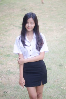 Taylandlı yetişkin öğrenci üniforması portresi. Güzel kız rahatla ve gülümse.