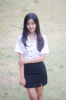 Taylandlı yetişkin öğrenci üniforması portresi. Güzel kız rahatla ve gülümse.