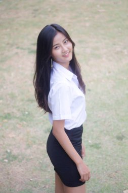 Taylandlı yetişkin öğrenci üniforması portresi. Güzel kız rahatla ve gülümse.