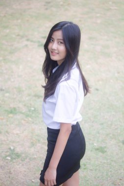 Taylandlı yetişkin öğrenci üniforması portresi. Güzel kız rahatla ve gülümse.