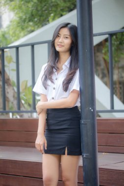 Taylandlı yetişkin öğrenci üniforması portresi. Güzel kız rahatla ve gülümse.