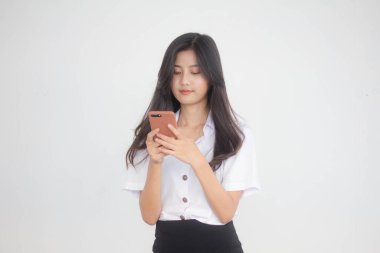 Taylandlı yetişkin öğrenci üniformasının portresi. Akıllı telefonunu kullanan güzel bir kız.