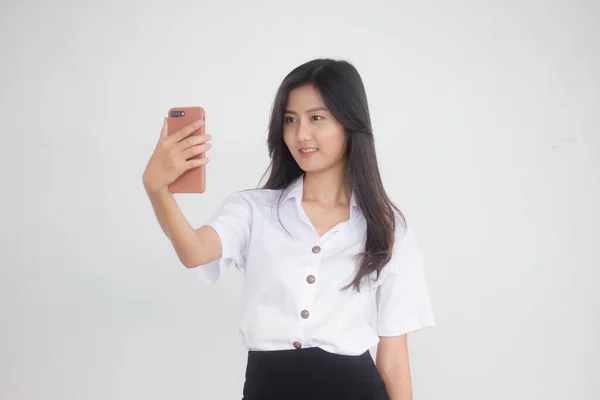 タイのポートレート大人学生大学制服美しいです女の子使用して彼女のスマートフォンSelfie — ストック写真