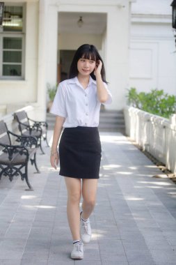 Taylandlı yetişkin öğrenci üniforması portresi. Güzel kız rahatla ve gülümse.