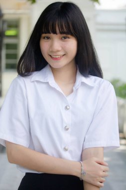 Taylandlı yetişkin öğrenci üniforması portresi. Güzel kız rahatla ve gülümse.