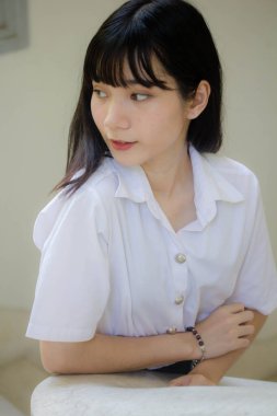 Taylandlı yetişkin öğrenci üniforması portresi. Güzel kız rahatla ve gülümse.