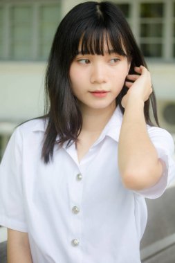 Taylandlı yetişkin öğrenci üniforması portresi. Güzel kız rahatla ve gülümse.