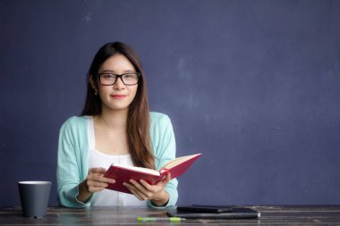 Tayland porseleni yetişkin ofis kızı gözlükleri kırmızı kitap okuyan beyaz gömlek